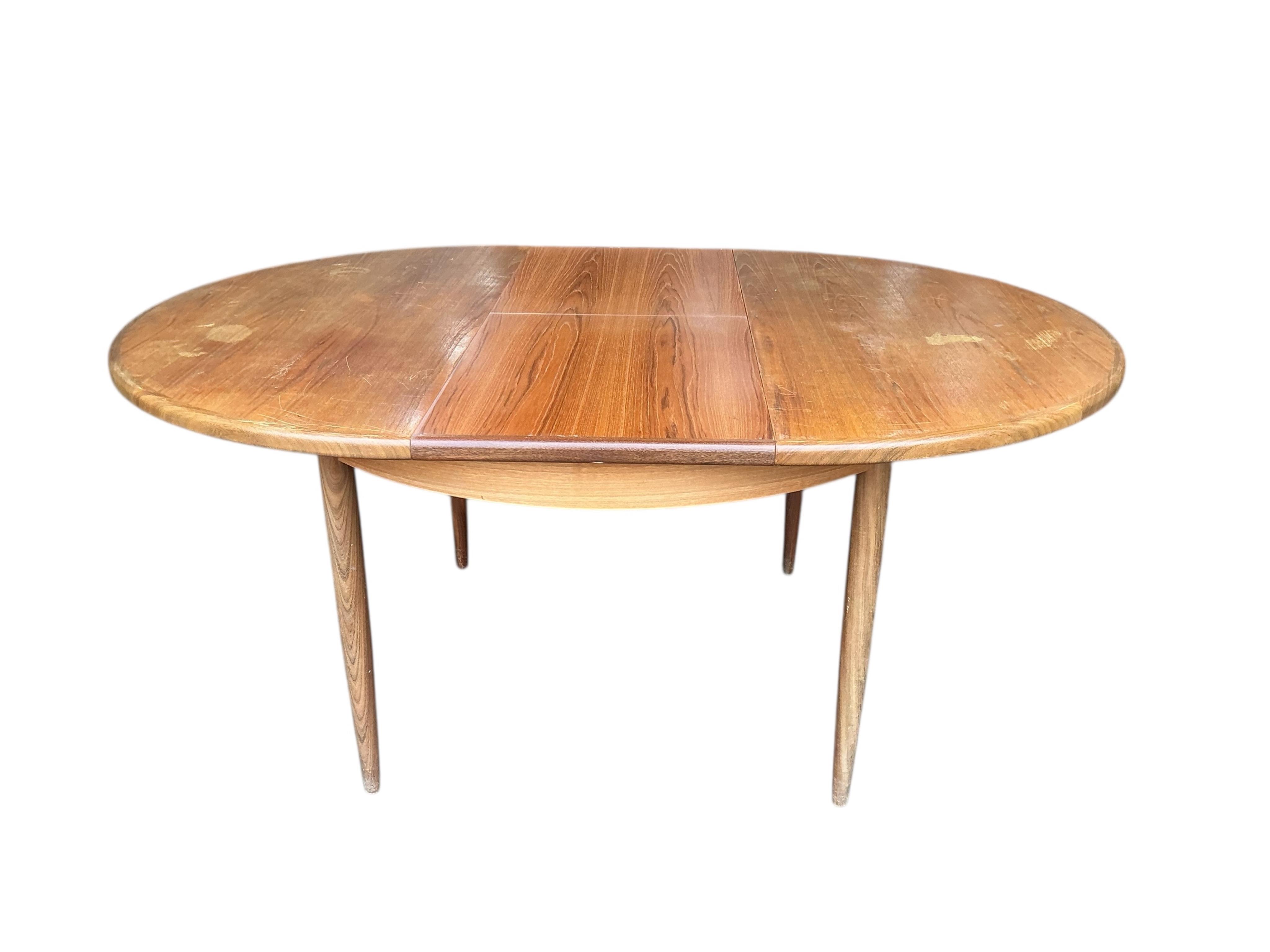 A mid century G Plan Fresco teak extending dining table, diameter 160cm, height 74cm, and four chairs